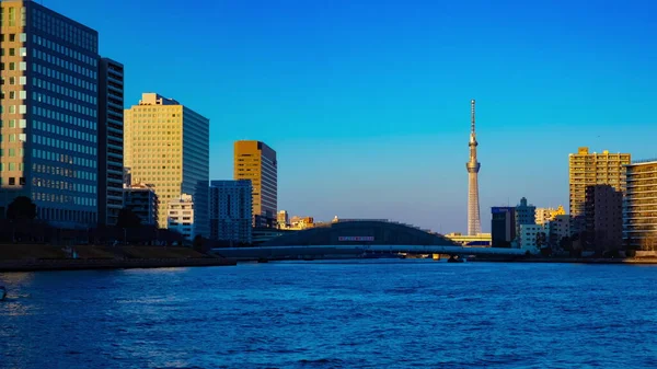 Solnedgång timelapse dag till natt vid Sumida floden i Tokyo panorering — Stockfoto