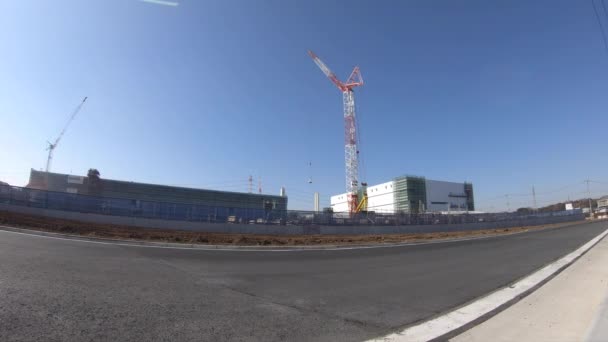 건설 중인 와이드 샷에서 푸른 하늘 뒤로 크레인을 움직이는 시간 경과 — 비디오