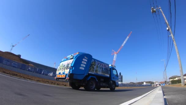 Um lapso de tempo de guindastes em movimento atrás do céu azul no tiro de largura sob construção — Vídeo de Stock