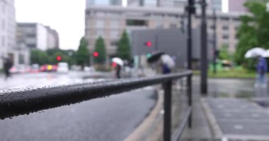 Marunouchi Tokyo 'nun yağmurlu günlerinde sokakta yürüyen insanlar. Yüksek kalite 4K görüntü. Chiyoda bölgesi Marunouchi Tokyo Japonya 05.13.2022