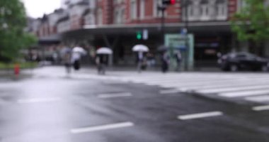 Marunouchi Tokyo 'nun yağmurlu günlerinde sokakta yürüyen insanlar. Yüksek kalite 4K görüntü. Chiyoda bölgesi Marunouchi Tokyo Japonya 05.13.2022