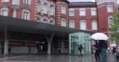 Marunouchi Tokyo 'nun yağmurlu günlerinde sokakta yürüyen insanlar. Yüksek kalite 4K görüntü. Chiyoda bölgesi Marunouchi Tokyo Japonya 05.13.2022