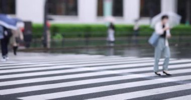Marunouchi Tokyo 'nun yağmurlu günlerinde sokakta yürüyen insanlar. Yüksek kalite 4K görüntü. Chiyoda bölgesi Marunouchi Tokyo Japonya 05.13.2022