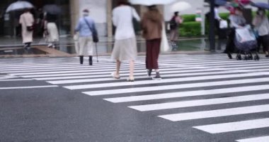 Marunouchi Tokyo 'nun yağmurlu günlerinde sokakta yürüyen insanlar. Yüksek kalite 4K görüntü. Chiyoda bölgesi Marunouchi Tokyo Japonya 05.13.2022