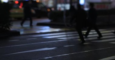 Walking people at the crossing rainy day at night. Shinjuku district Tokyo Japan - 01.09.2020 : It s legs of the people on the crossing.