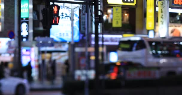 交通信号灯和人们在十字路口的雨天晚上 Shinjku District Tokyo Japan 2020 Translation Neon Board Text — 图库视频影像