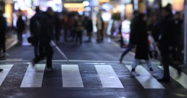 Walking people at the crossing rainy day at night. Shinjuku district Tokyo Japan - 01.09.2020 : It s legs of the people on the crossing.