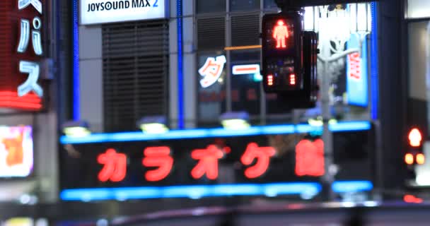 交差点の雨の日の夜に交通信号 新宿区東京都 2020 ネオンボードのテキストショップ名 — ストック動画