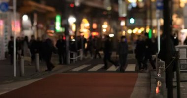 Walking people at the neon town at night long shot handheld. Minato district Shinbashi Tokyo Japan - 01.16.2020 : It is downtown in Tokyo
