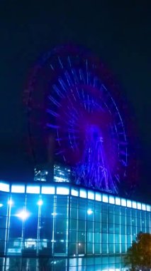 Gece dikey çekimde nehir kenarındaki dönme dolap. Koutou-ku Odaiba Tokyo Japonya - 12.18.2018: Gece dönme dolap. 4K zaman aşımı. Kamera: Canon EOS 5D işaret 4