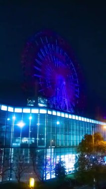 Gece dikey çekimde nehir kenarındaki dönme dolap. Koutou-ku Odaiba Tokyo Japonya - 12.18.2018: Gece dönme dolap. 4K zaman aşımı. Kamera: Canon EOS 5D işaret 4