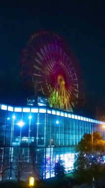 Gece dikey çekimde nehir kenarındaki dönme dolap. Koutou-ku Odaiba Tokyo Japonya - 12.18.2018: Gece dönme dolap. 4K zaman aşımı. Kamera: Canon EOS 5D işaret 4