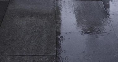 Şehir sokaklarında yağmurlu bir günde su birikintisi. Yüksek kalite 4K görüntü. Chiyoda bölgesi Marunouchi Tokyo Japonya 05.13.2022