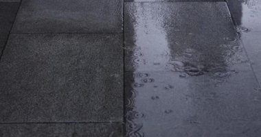 Şehir sokaklarında yağmurlu bir günde su birikintisi. Yüksek kalite 4K görüntü. Chiyoda bölgesi Marunouchi Tokyo Japonya 05.13.2022