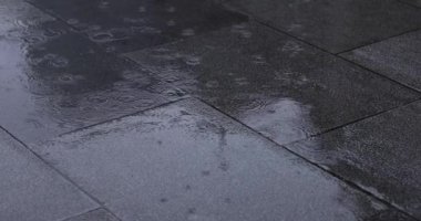 Şehir sokaklarında yağmurlu bir günde su birikintisi. Yüksek kalite 4K görüntü. Chiyoda bölgesi Marunouchi Tokyo Japonya 05.13.2022