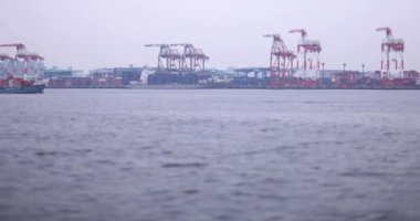 Tokyo Bulutlu Günü 'nde minyatür konteynır iskelesinin yanında bir yolcu gemisi. Yüksek kalite 4K görüntü. Koto bölgesi Aomi Tokyo Japonya 05.20.2022 Burası Ooi Konteynır Rıhtımı. Konteynırlardan biri.