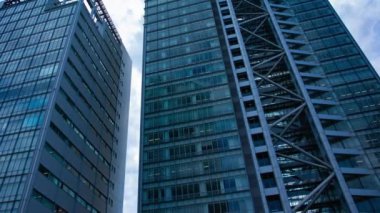 A timelapse of cloud at the building in the business town wide shot panning. High quality 4k footage. Nakano district Nakanosakaue Tokyo Japan 07.20.2022 Here is a center of the city in Tokyo. 