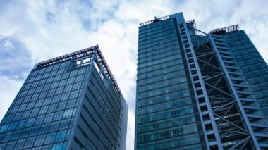 A timelapse of cloud at the building in the business town wide shot panning. High quality 4k footage. Nakano district Nakanosakaue Tokyo Japan 07.20.2022 Here is a center of the city in Tokyo. 
