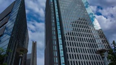 A timelapse of cloud at the building in the business town wide shot panning. High quality 4k footage. Nakano district Nakanosakaue Tokyo Japan 07.20.2022 Here is a center of the city in Tokyo. 