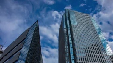 A timelapse of cloud at the building in the business town wide shot panning. High quality 4k footage. Nakano district Nakanosakaue Tokyo Japan 07.20.2022 Here is a center of the city in Tokyo. 