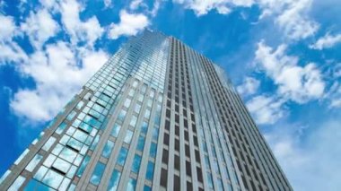 A timelapse of cloud at the building in the business town wide shot panning. High quality 4k footage. Nakano district Nakanosakaue Tokyo Japan 07.20.2022 Here is a center of the city in Tokyo. 