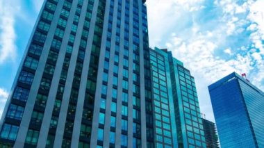 A timelapse of cloud at the building in the business town wide shot zoom. High quality 4k footage. Nakano district Nakanosakaue Tokyo Japan 07.20.2022 Here is a center of the city in Tokyo. 