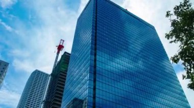 A timelapse of cloud at the building in the business town wide shot zoom. High quality 4k footage. Nakano district Nakanosakaue Tokyo Japan 07.20.2022 Here is a center of the city in Tokyo. 