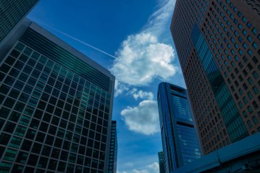 A cloud reflecting the building in the business town wide shot. High quality photo. Minato district Shiodome Tokyo Japan 07.25.2022 Here is a center of the city in Tokyo. 