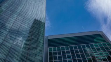 A timelapse of cloud reflecting the building in the business town wide shot panning. High quality 4k footage. Minato district Shiodome Tokyo Japan 07.25.2022 Here is a center of the city in Tokyo. 