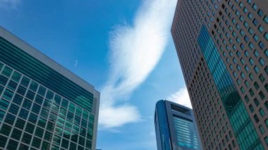 A timelapse of cloud reflecting the building in the business town wide shot panning. High quality 4k footage. Minato district Shiodome Tokyo Japan 07.25.2022 Here is a center of the city in Tokyo. 