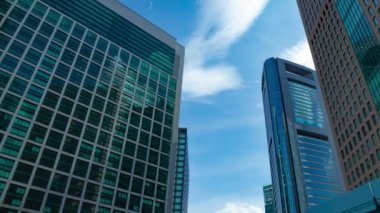 A timelapse of cloud reflecting the building in the business town wide shot panning. High quality 4k footage. Minato district Shiodome Tokyo Japan 07.25.2022 Here is a center of the city in Tokyo. 