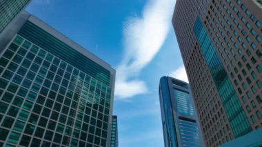 A timelapse of cloud reflecting the building in the business town wide shot tilt. High quality 4k footage. Minato district Shiodome Tokyo Japan 07.25.2022 Here is a center of the city in Tokyo. 