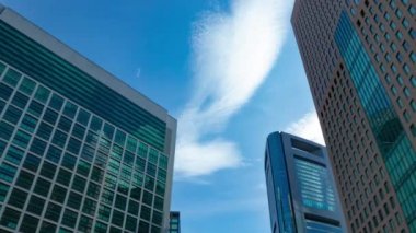 A timelapse of cloud reflecting the building in the business town wide shot zoom. High quality 4k footage. Minato district Shiodome Tokyo Japan 07.25.2022 Here is a center of the city in Tokyo. 