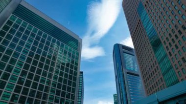 A timelapse of cloud reflecting the building in the business town wide shot tilt. High quality 4k footage. Minato district Shiodome Tokyo Japan 07.25.2022 Here is a center of the city in Tokyo. 