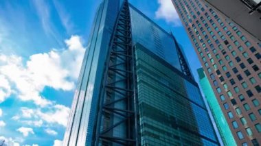 A timelapse of cloud reflecting the building in the business town wide shot tilt. High quality 4k footage. Minato district Shiodome Tokyo Japan 07.25.2022 Here is a center of the city in Tokyo. 