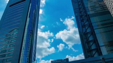 A timelapse of cloud reflecting the building in the business town wide shot panning. High quality 4k footage. Minato district Shiodome Tokyo Japan 07.25.2022 Here is a center of the city in Tokyo. 