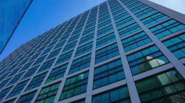 A timelapse of cloud reflecting the building in the business town wide shot zoom. High quality 4k footage. Minato district Shiodome Tokyo Japan 07.25.2022 Here is a center of the city in Tokyo. 