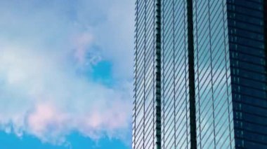 A timelapse of cloud reflecting the building in the business town long shot tilt. High quality 4k footage. Minato district Shiodome Tokyo Japan 07.25.2022 Here is a center of the city in Tokyo. 