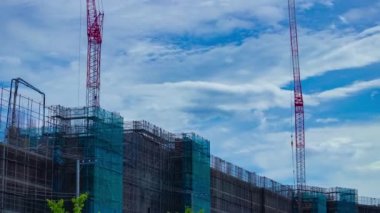 A timelapse of moving cranes at the under construction daytime. High quality 4k footage. Nerima district Shakujii Tokyo Japan 07.27.2022
