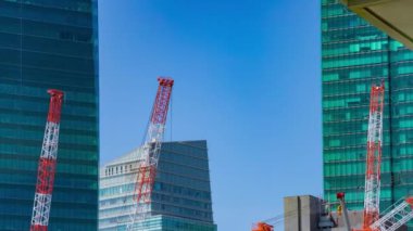A timelapse of crane at the under construction in Tokyo long shot. High quality 4k footage. Minato district Iikurakatamachi Tokyo Japan 08.09.2022 It is center of the city in Tokyo.