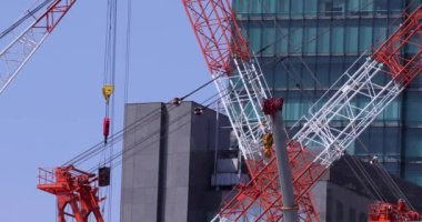 Moving cranes at the under construction daytime long shot. High quality 4k footage. Minato district Iikurakatamachi Tokyo Japan 08.09.2022 It is center of the city in Tokyo.