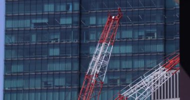 Moving cranes at the under construction daytime long shot. High quality 4k footage. Minato district Iikurakatamachi Tokyo Japan 08.09.2022 It is center of the city in Tokyo.