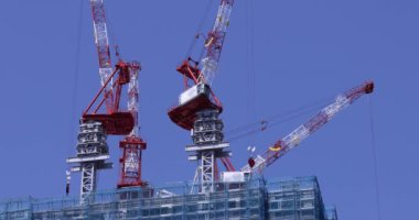 Moving cranes at the under construction daytime long shot. High quality 4k footage. Minato district Iikurakatamachi Tokyo Japan 08.09.2022 It is center of the city in Tokyo.