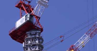 Moving cranes at the under construction daytime long shot. High quality 4k footage. Minato district Iikurakatamachi Tokyo Japan 08.09.2022 It is center of the city in Tokyo.