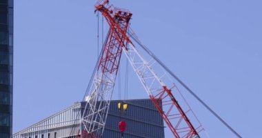 Moving cranes at the under construction daytime long shot. High quality 4k footage. Minato district Iikurakatamachi Tokyo Japan 08.09.2022 It is center of the city in Tokyo.