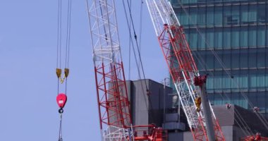 Moving cranes at the under construction daytime long shot. High quality 4k footage. Minato district Iikurakatamachi Tokyo Japan 08.09.2022 It is center of the city in Tokyo.