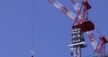 Moving cranes at the under construction daytime long shot. High quality 4k footage. Minato district Iikurakatamachi Tokyo Japan 08.09.2022 It is center of the city in Tokyo.