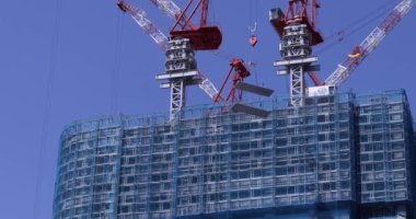 Moving cranes at the under construction daytime long shot. High quality 4k footage. Minato district Iikurakatamachi Tokyo Japan 08.09.2022 It is center of the city in Tokyo.