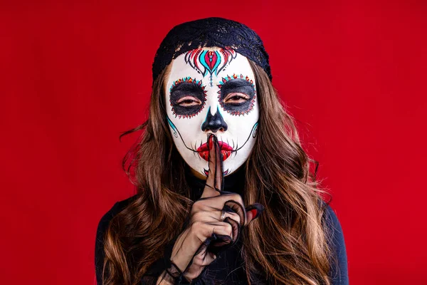 Mexikói fiatal nő jelmezben Calavera Catrina felett piros stúdió háttér — Stock Fotó