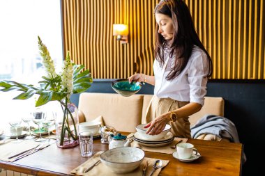 Arap tasarımcı görgü öğretmeni restoranda tabakları ne kadar doğru koyduğunu gösteriyor.